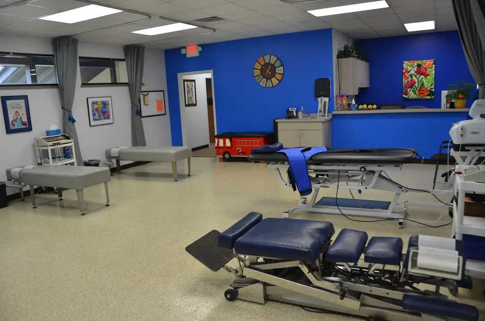 Interior of Aascend Chiropractic in Appleton, showing the reception counter, a blue accent wall and the kid friendly firetruck bench